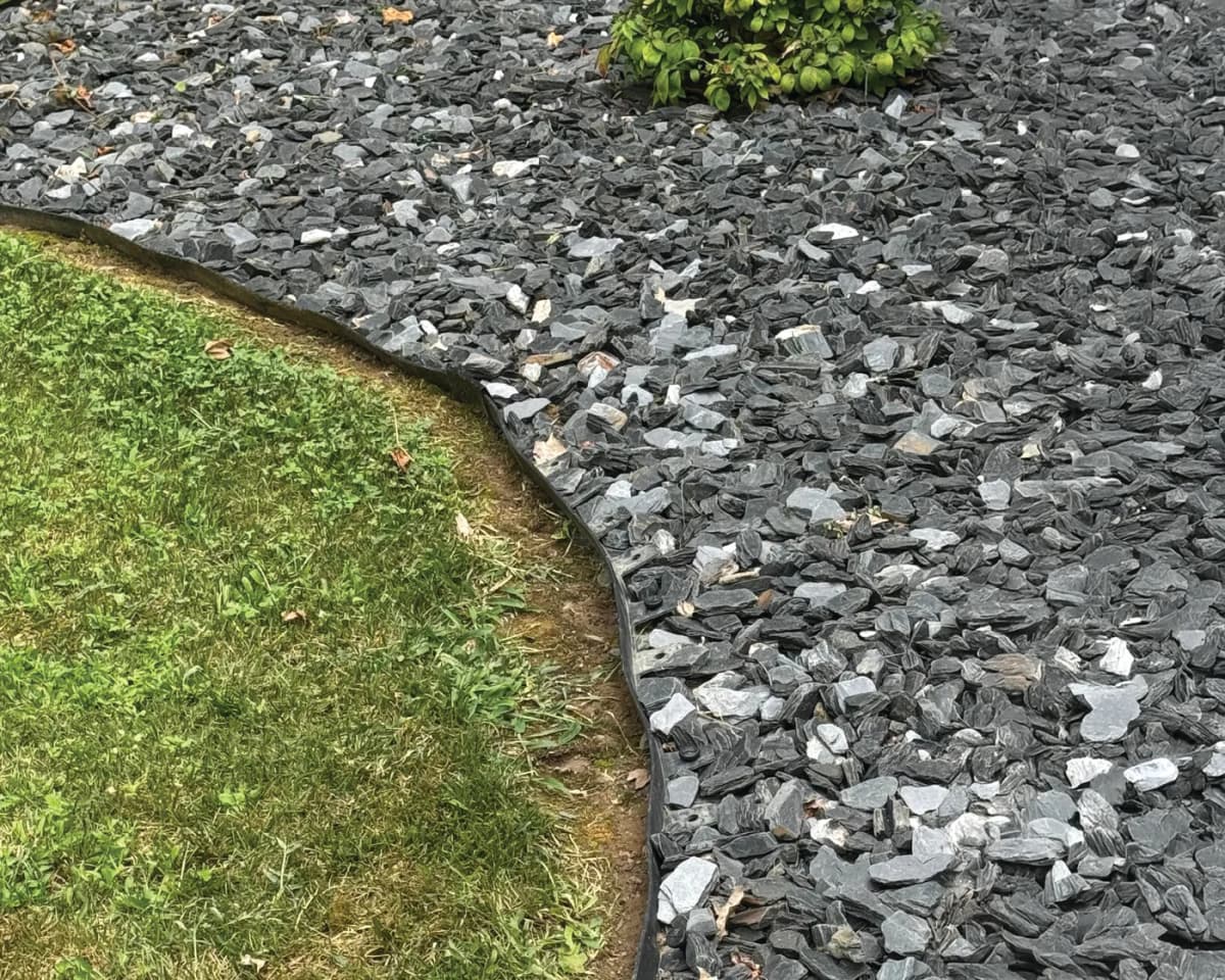 Plastic edging separates lawn and a gravel bed